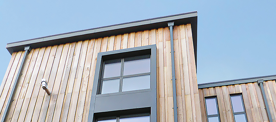 smoothline square downpipe with rectangular hopper and box guttering complimenting modern wooden and stone build