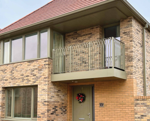 Modern Brick Building with Green Balcony, Soffits & Door | Guttercrest