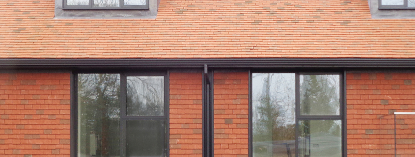 Moulded ogee gutter system with round downpipe in RAL 7021 anthracite grey matt finish